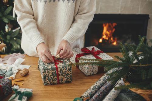 Person packing Christmas gifts on a budget