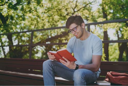 Man reading a book outdoors 