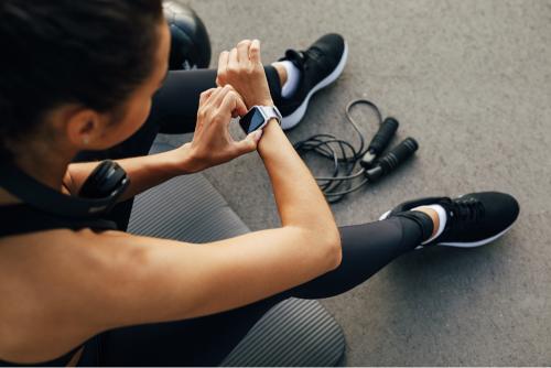 Girl using cheap activity tracker in the gym 