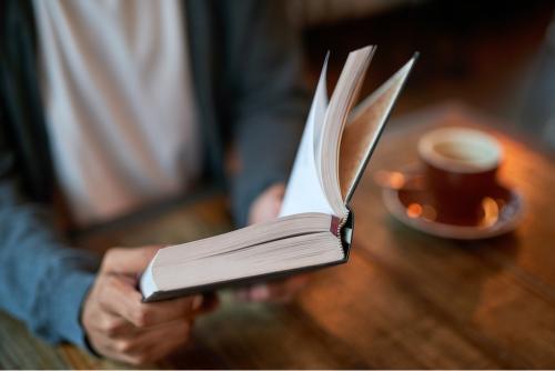 Person reading a book in a café 